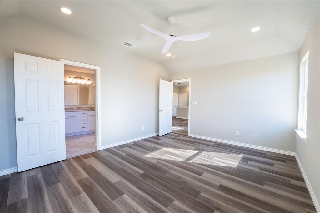 1020 Springview Lane Mabank, TX 75147 - Photo 6 of 15 Unfurnished bedroom featuring vaulted ceiling, ceiling fan, recessed lighting, dark wood-style floors, and ensuite bathroom