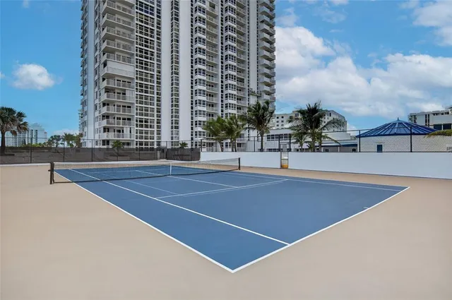 a tennis court with tall buildings