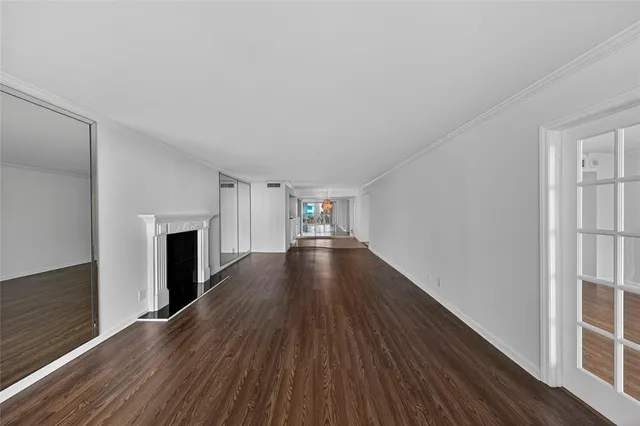 a view of a livingroom with wooden floor and a fireplace