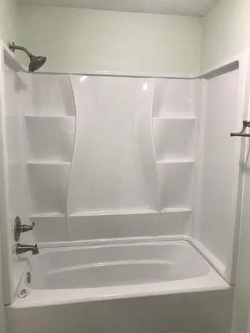 a bathroom with a shower and a bath tub