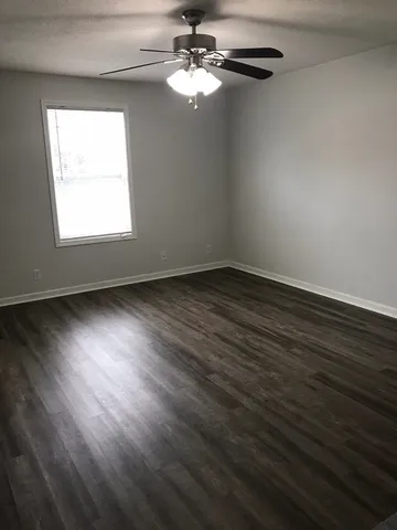 a view of room with window ceiling fan and hardwood floor