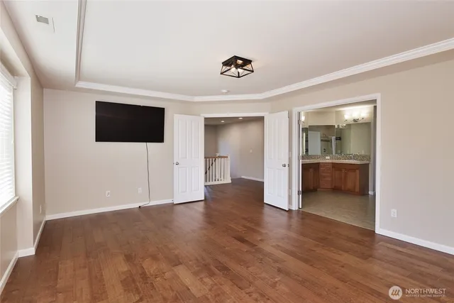 a view of a livingroom with wooden floor and a flat screen tv
