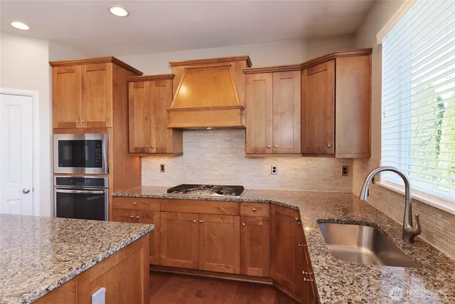 a kitchen with stainless steel appliances granite countertop a sink stove and refrigerator