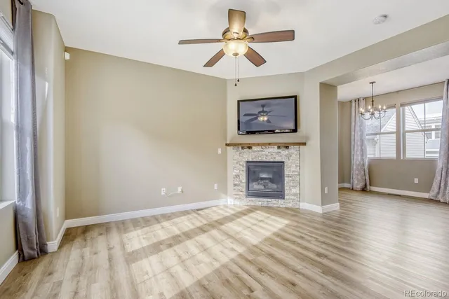 a view of a livingroom with a fireplace a chandelier and wooden floor