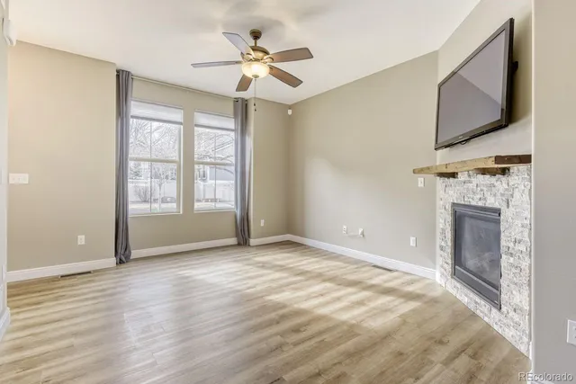 a view of an empty room with a fireplace and a flat screen tv