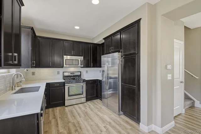 a kitchen with stainless steel appliances granite countertop a refrigerator stove and sink