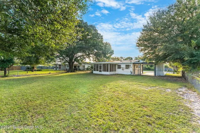 a view of a house with garden and trees