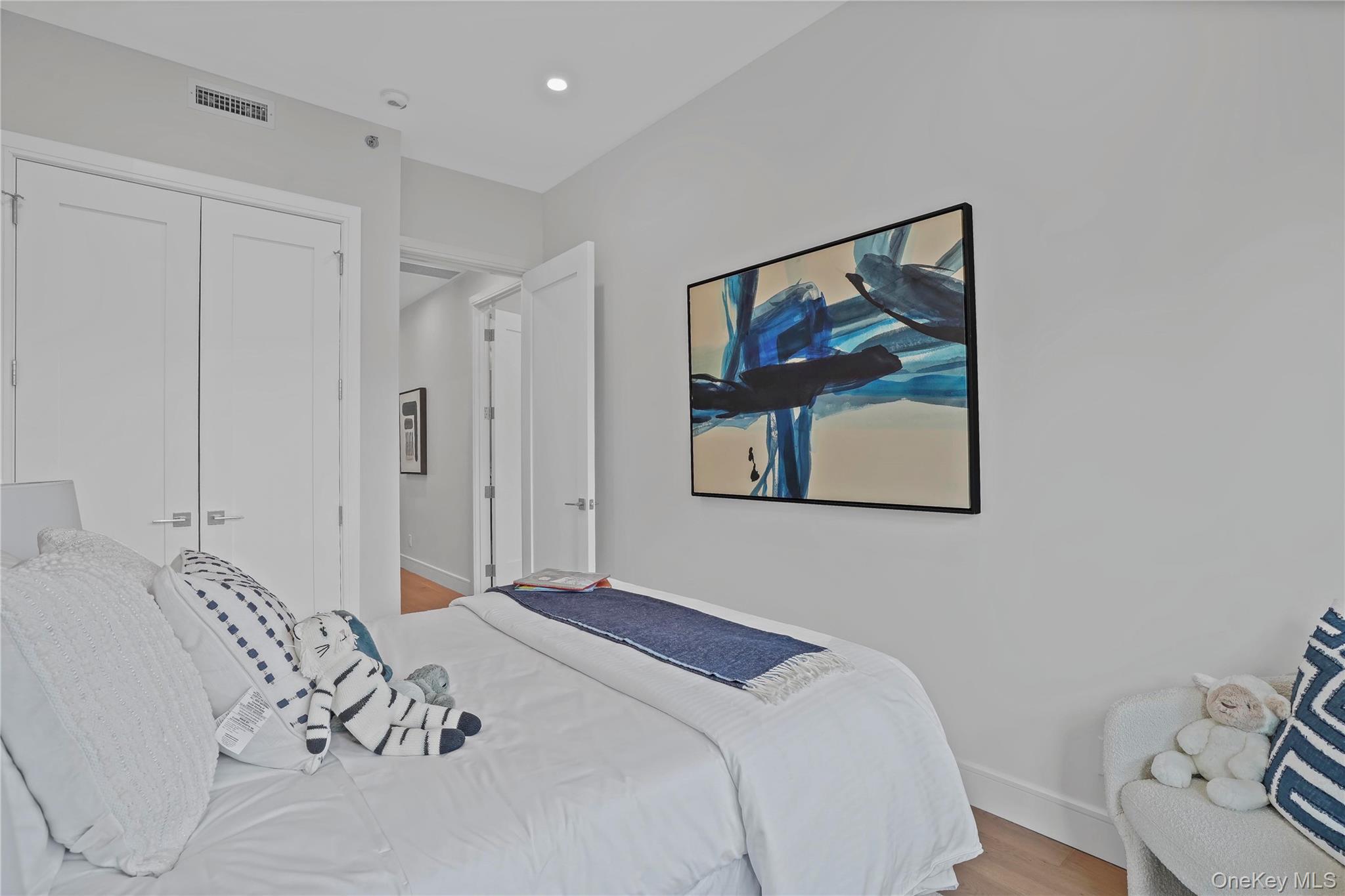 21-31 Shore Boulevard, Unit 1E Queens, NY 11105 - Photo 6 of 12 a bedroom with a large bed and a painting on the wall