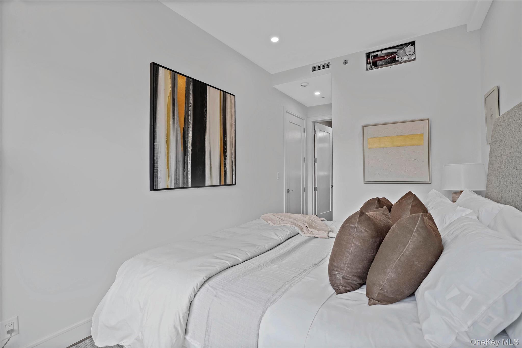 21-31 Shore Boulevard, Unit 1E Queens, NY 11105 - Photo 9 of 12 a bedroom with a bed and a painting on the wall