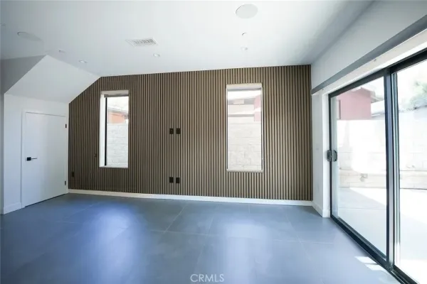 a view of an empty room with wooden floor and closet