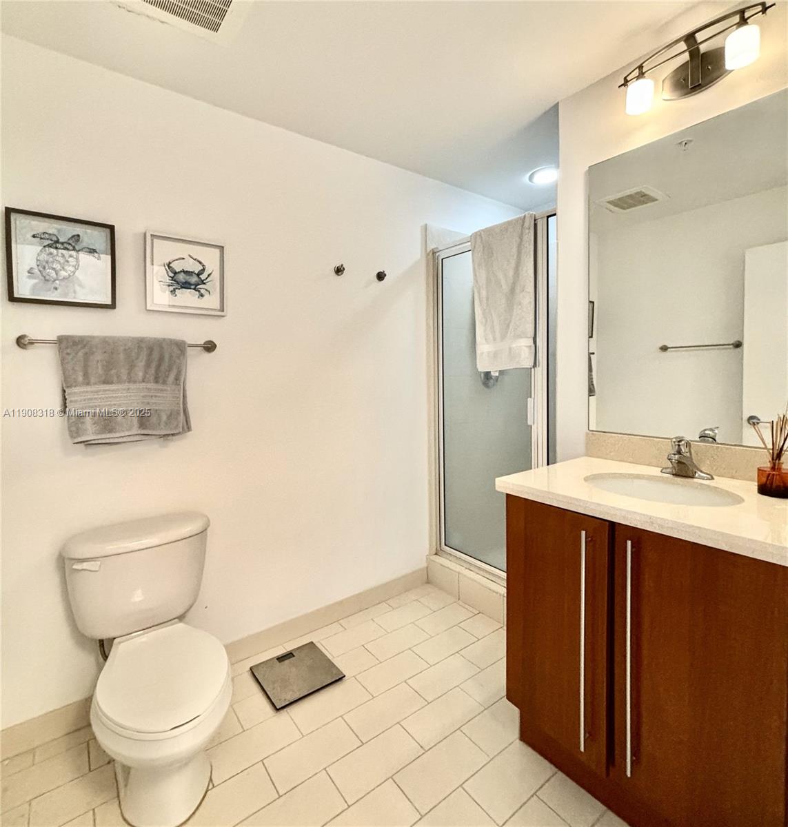 79 Southwest 12th Street, Unit 4012S Miami, FL 33130 - Photo 13 of 34 a bathroom with a toilet sink vanity and mirror