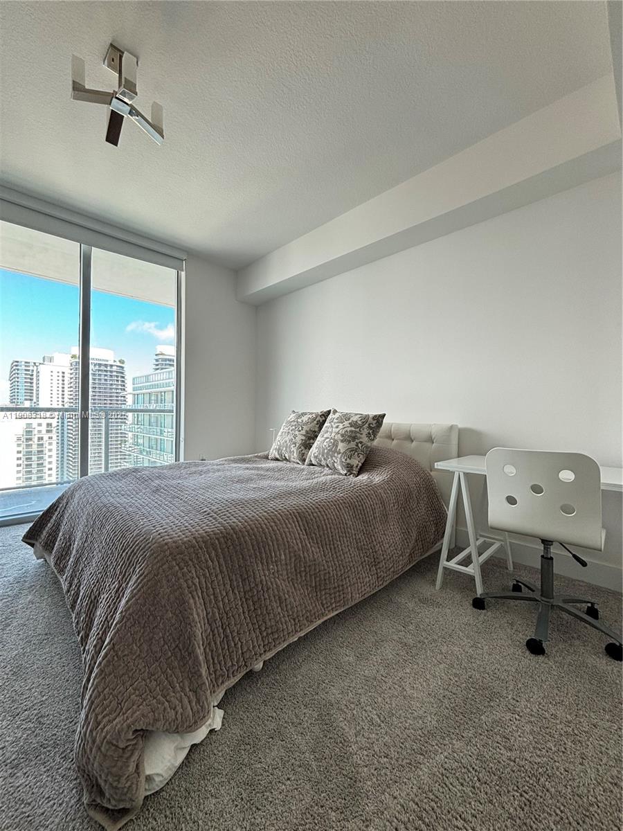 79 Southwest 12th Street, Unit 4012S Miami, FL 33130 - Photo 16 of 34 a bedroom with a bed and large mirror