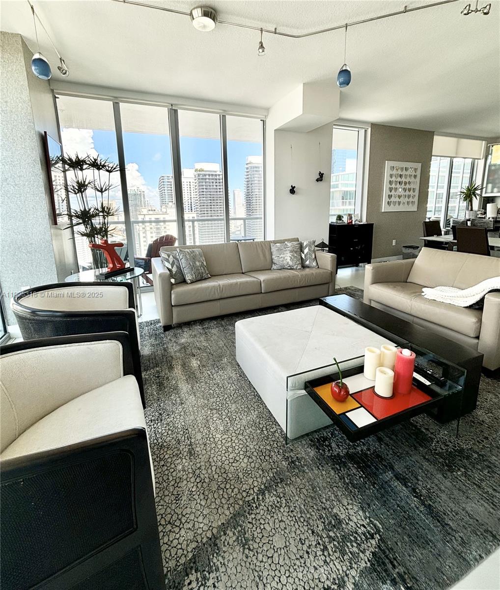 79 Southwest 12th Street, Unit 4012S Miami, FL 33130 - Photo 5 of 34 a living room with furniture a rug and a chandelier