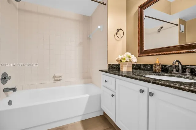 a kitchen with stainless steel appliances granite countertop a stove a refrigerator a oven and white cabinets