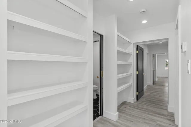a view of a livingroom with wooden floor and a ceiling fan