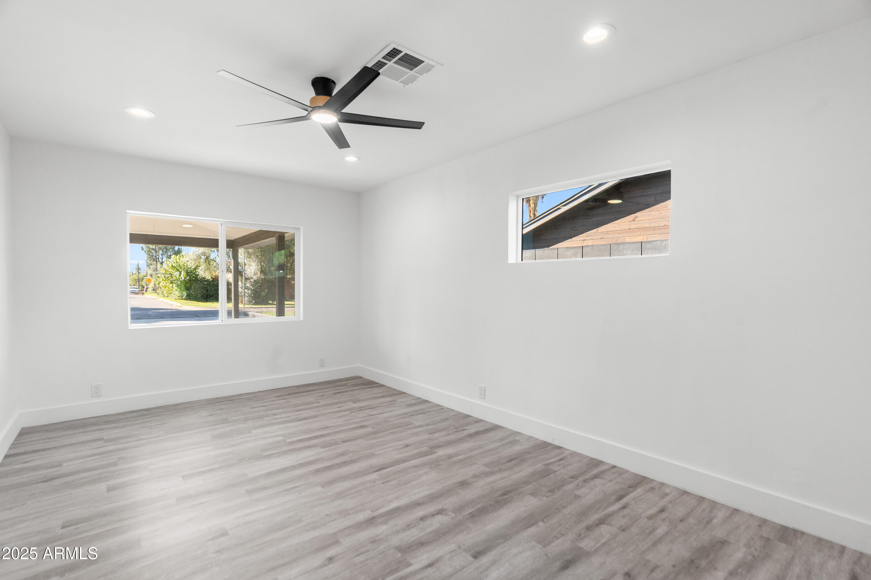 2502 East Whitton Avenue Phoenix, AZ 85016 - Photo 19 of 34 an empty room with wooden floor ceiling fan and windows