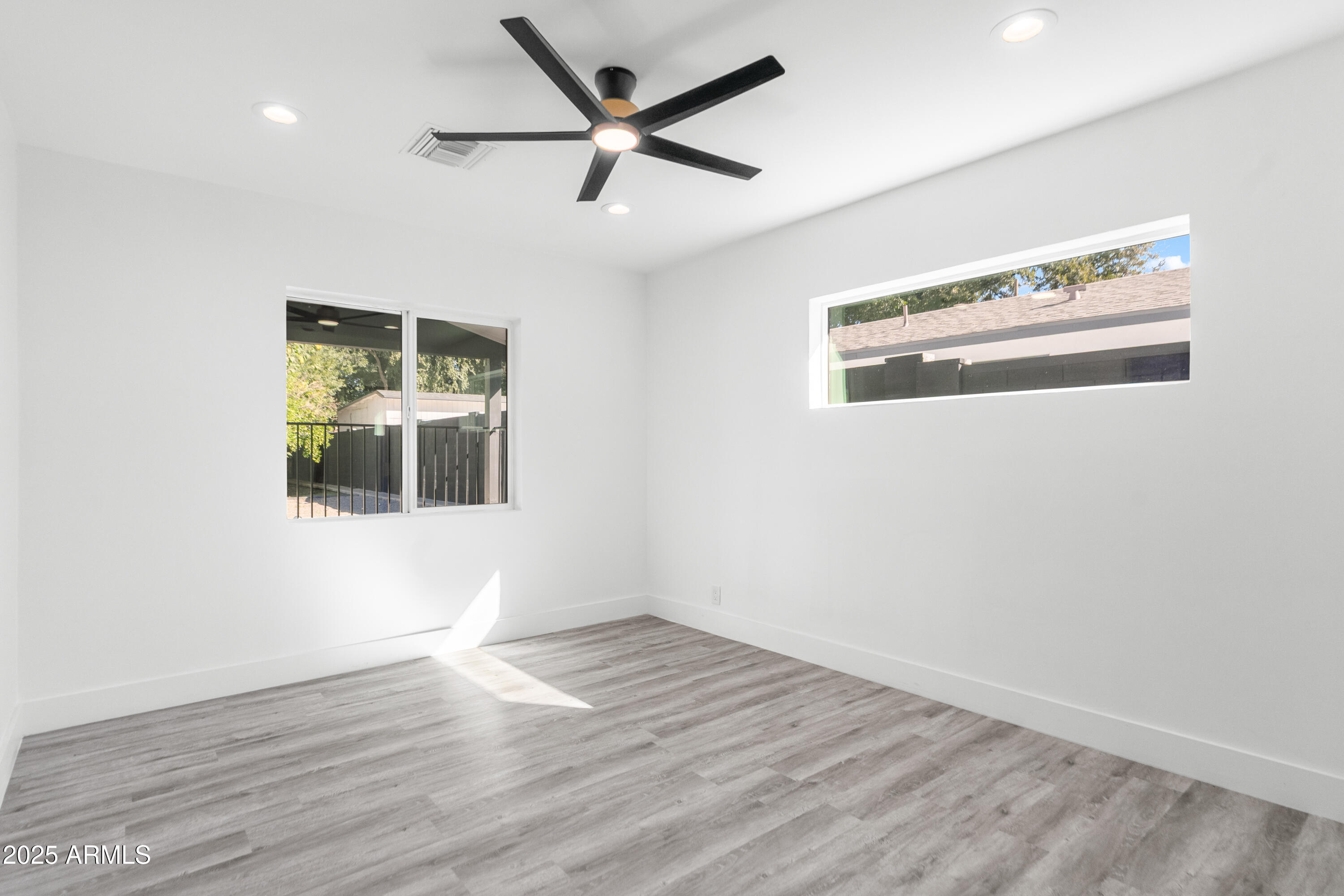 2502 East Whitton Avenue Phoenix, AZ 85016 - Photo 22 of 34 an empty room with wooden floor and windows