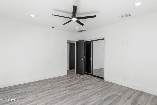 an empty room with wooden floor and windows