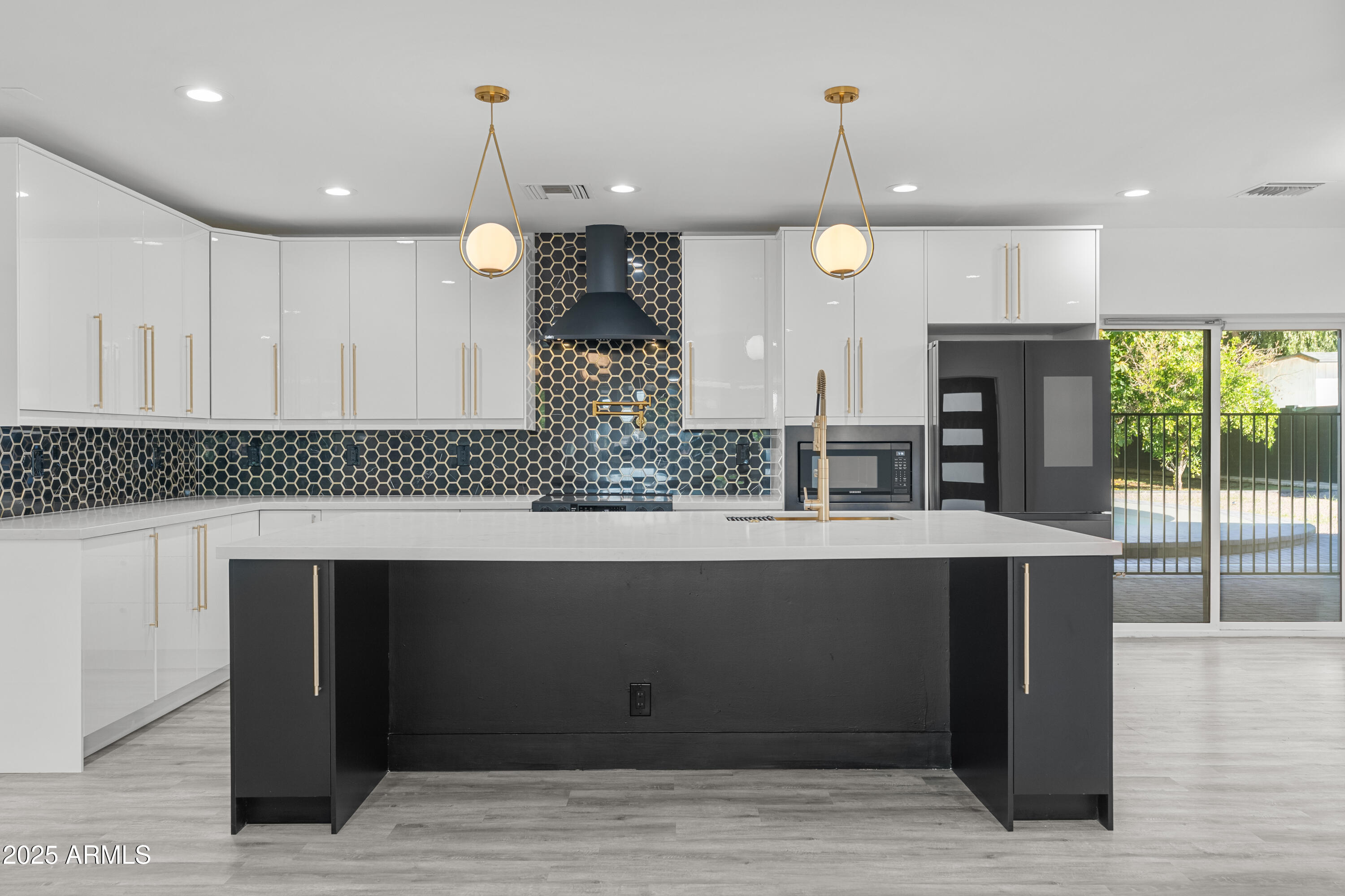 2502 East Whitton Avenue Phoenix, AZ 85016 - Photo 7 of 34 a kitchen with stainless steel appliances granite countertop a large island in the center and wooden floors