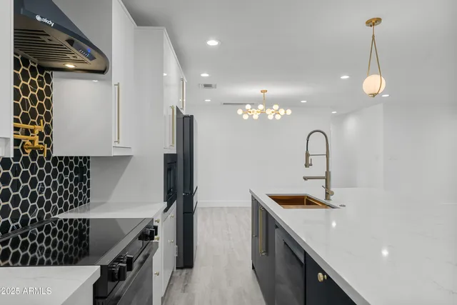 a kitchen with stainless steel appliances granite countertop a large island in the center and wooden floors