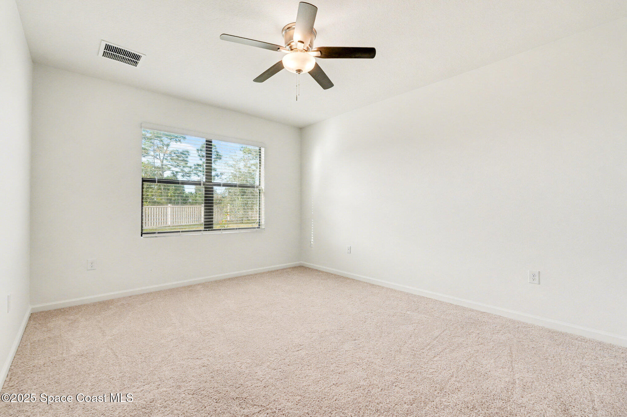 4604 Magenta Isles Drive Melbourne, FL 32904 - Photo 14 of 17 an empty room with windows and fan