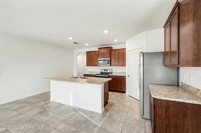 a kitchen with stainless steel appliances granite countertop a stove a refrigerator and a sink