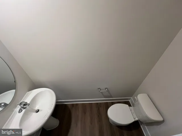 a bathroom with a toilet mirror and sink