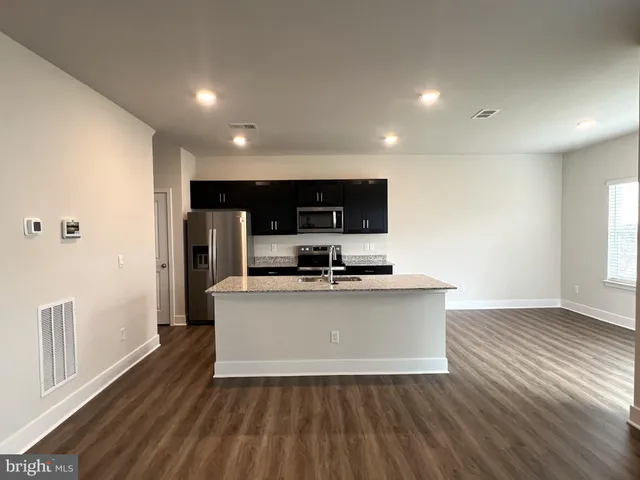 a view of kitchen with microwave stove refrigerator and cabinets