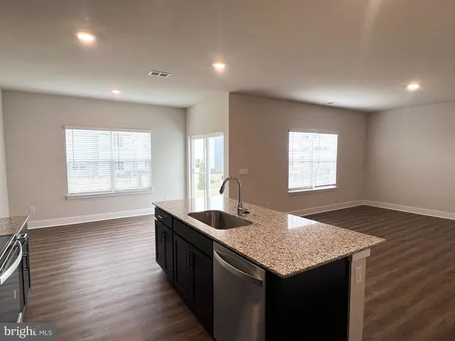 a kitchen with granite countertop sink stove and granite counter top