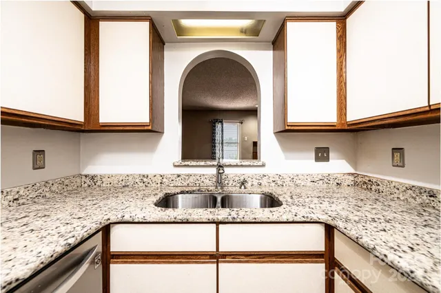 a view of a kitchen with granite countertop sink and cabinets
