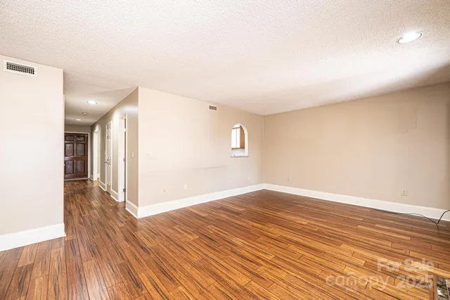 a view of an empty room and wooden floor