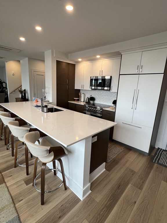 a kitchen with stainless steel appliances a table and chairs in it