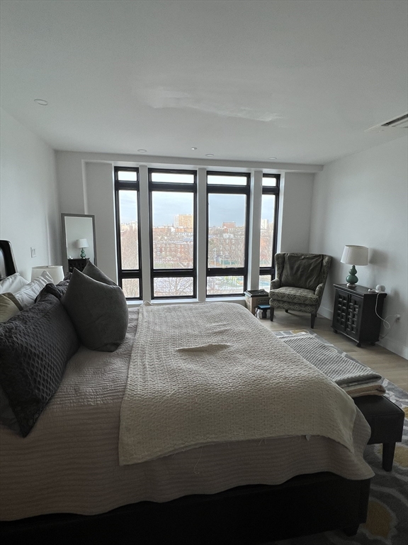 1950 Washington Street, Unit 5C Boston, MA 02118 - Photo 7 of 11 a bedroom with a bed a couch and large window