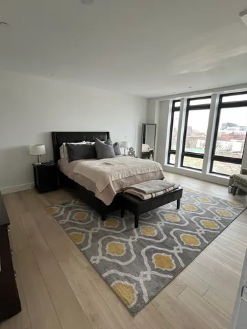 a bedroom with a bed and a large window