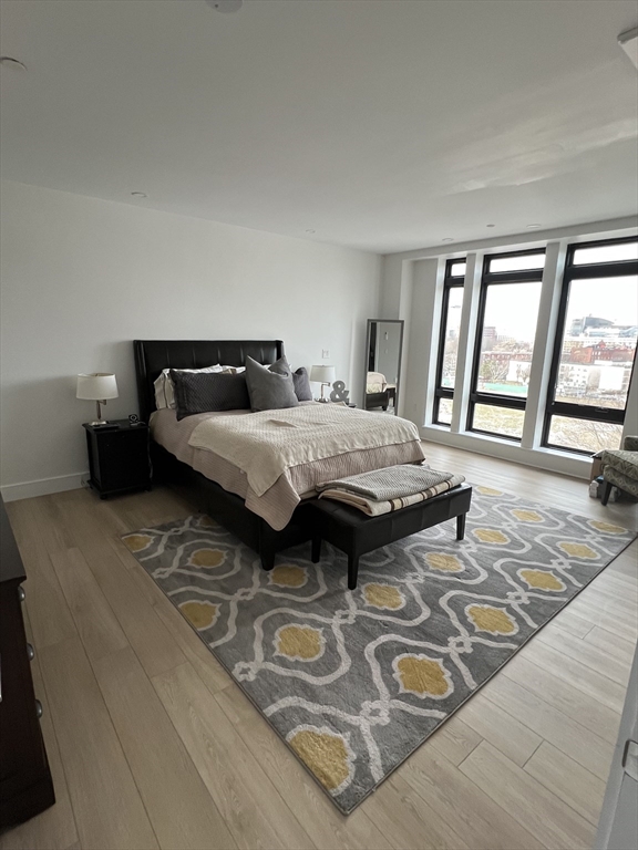 1950 Washington Street, Unit 5C Boston, MA 02118 - Photo 9 of 11 a bedroom with a bed and a large window