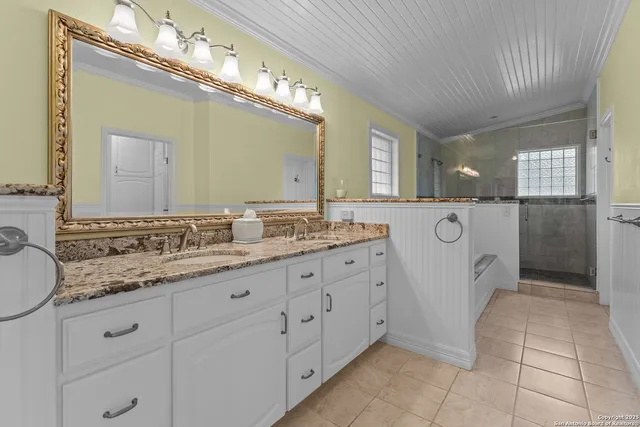 a spacious bathroom with a granite countertop sink a mirror and a