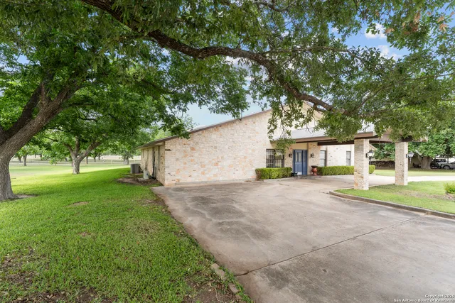 a front view of a house with a yard and trees