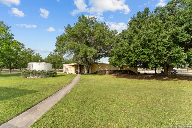 a view of a house with a yard and basketball court