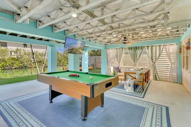 a room with pool table and windows