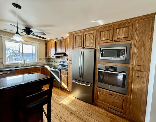 a kitchen with a stove and a wooden floor