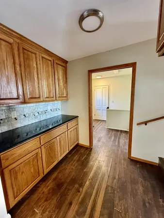 a kitchen with stainless steel appliances granite countertop a stove a sink dishwasher and a microwave with wooden floor