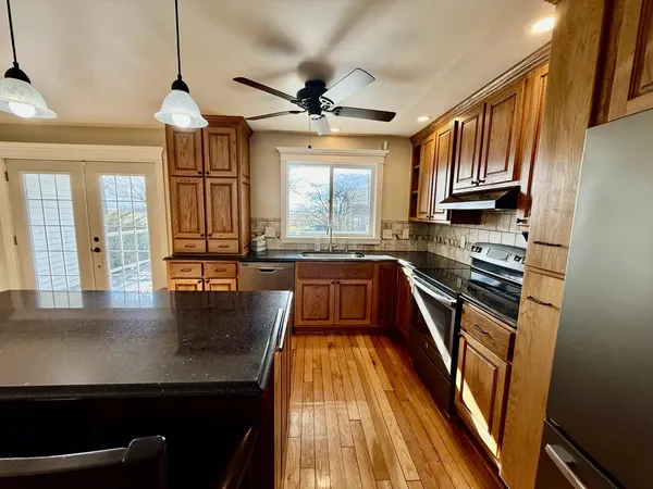 a kitchen with a stove and a wooden floor