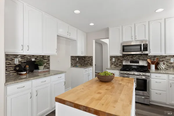 a kitchen with a stove and white cabinets