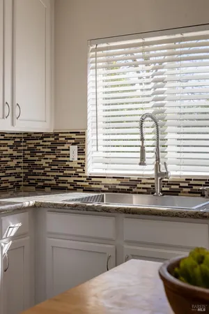 a kitchen with stainless steel appliances granite countertop a sink a stove a kitchen island with chairs and cabinets