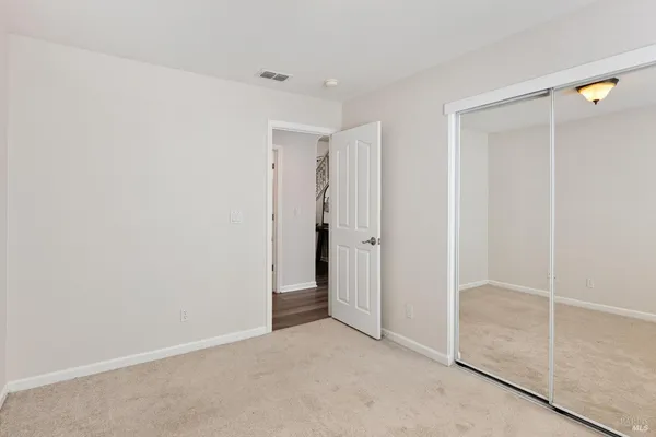 a bedroom with a bed a chandelier and next to a window