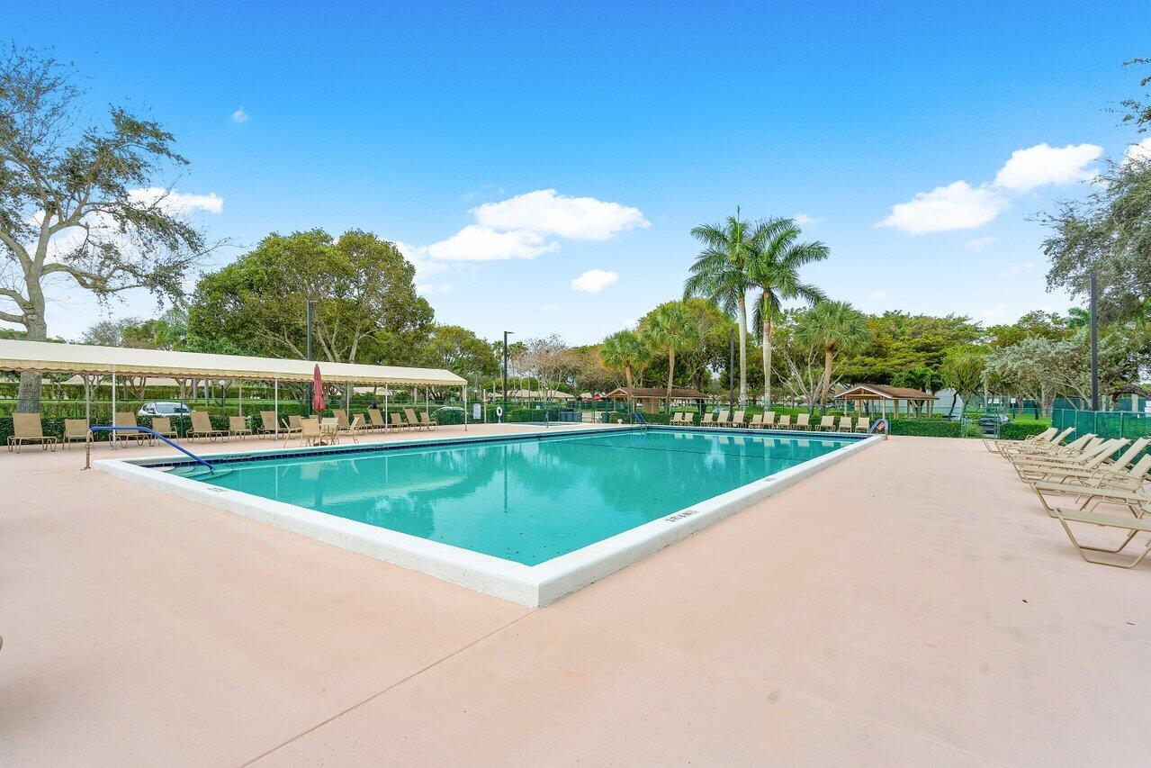 8299 Springlake Drive, Unit B Boca Raton, FL 33496 - Photo 23 of 31 a view of a swimming pool and a yard