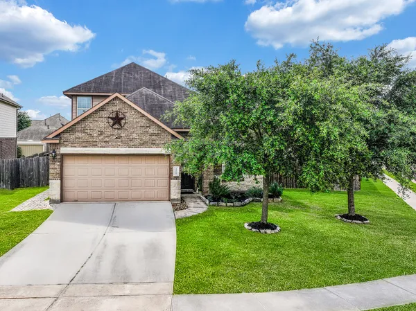 a front view of a house with a yard and tree