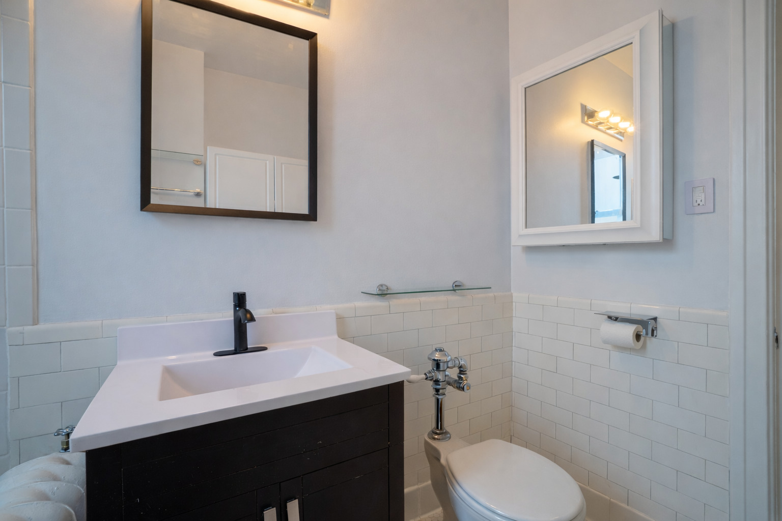 1765 East 55th Street, Unit E1 Chicago, IL 60637 - Photo 14 of 18 a bathroom with a toilet a sink and mirror