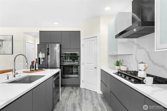 a kitchen with stainless steel appliances a sink stove and refrigerator