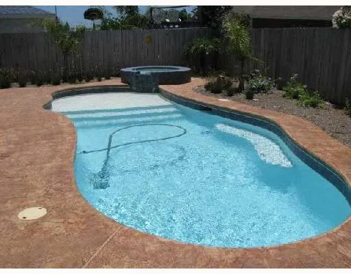 a view of a backyard with plants and wooden fence
